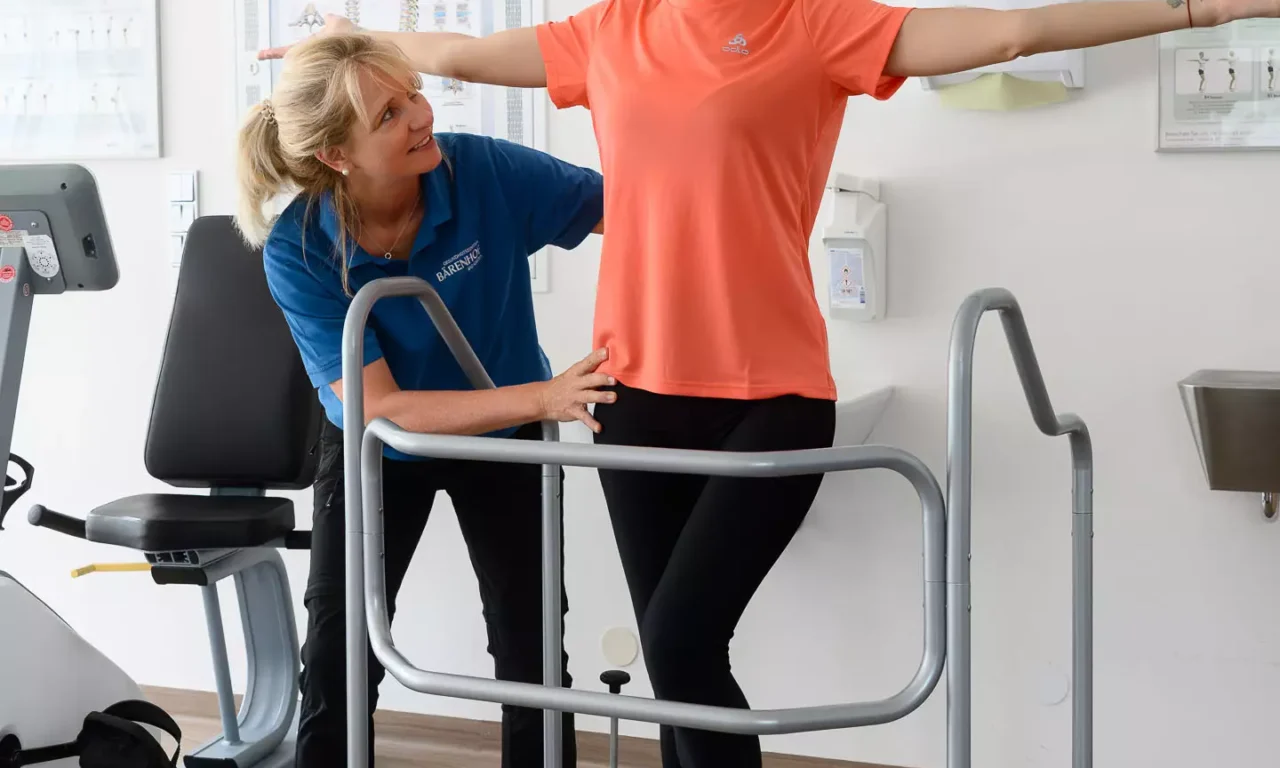 Therapeutin begleitet Patientin bei sensomotorischem Gleichgewichtstraining auf dem Posturomed im MTT-Raum des Bärenhofs.