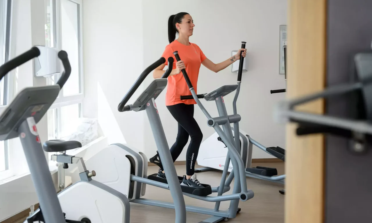 Frau trainiert im Fitnessbereich des Bärenhofs auf einem Crosstrainer zur Förderung von Ausdauer und Gelenkschonung.