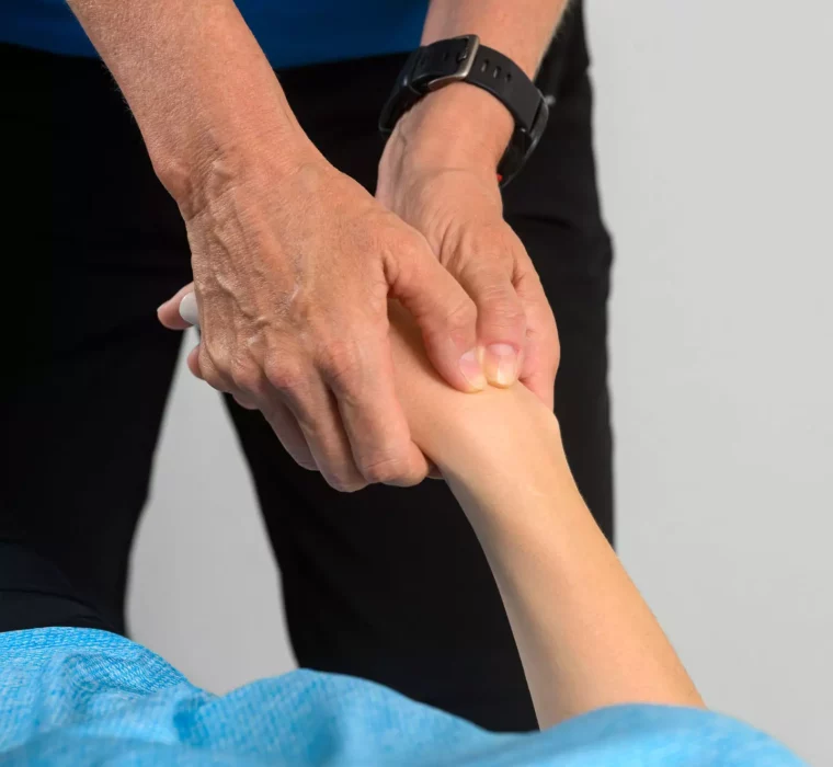 Detailaufnahme einer manuellen Mobilisation des Handgelenks durch eine Therapeutin im Bärenhof zur Förderung der Gelenkfunktion und Schmerzlinderung.