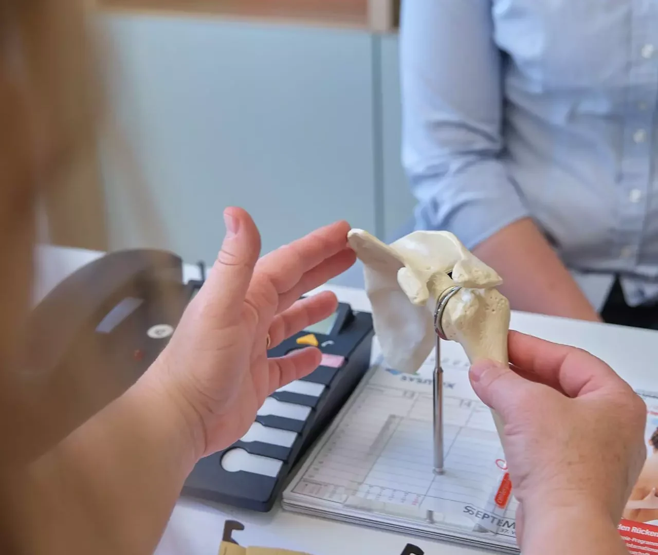 Ärztin erklärt Patientin anhand eines Schultergelenk-Modells im Gesundheitszentrum Bärenhof Bad Gastein Beratung zur