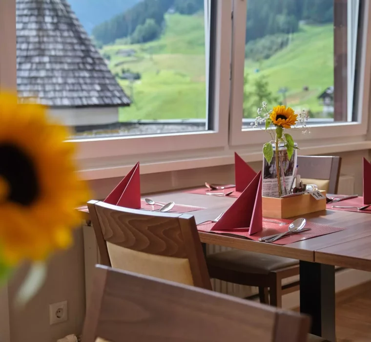Essbereich im Gesundheitszentrum Bärenhof Bad Gastein mit gedeckten Tischen und Blick auf grüne Berglandschaft
