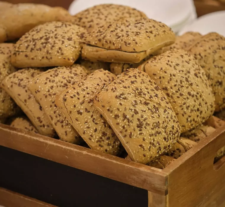 Holzkiste mit frisch gebackenen, mit Samen bestreuten Vollkornbrötchen im Gesundheitszentrum Bärenhof Bad Gastein