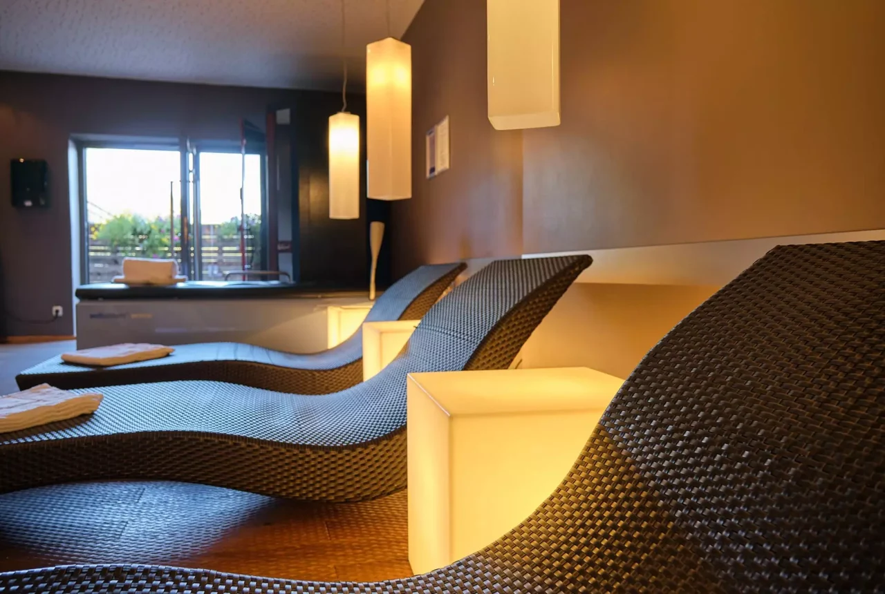 Entspannte Liegen im Wellnessbereich des Gesundheitszentrums Bärenhof Bad Gastein mit warmem Licht und offenem Fenster zur