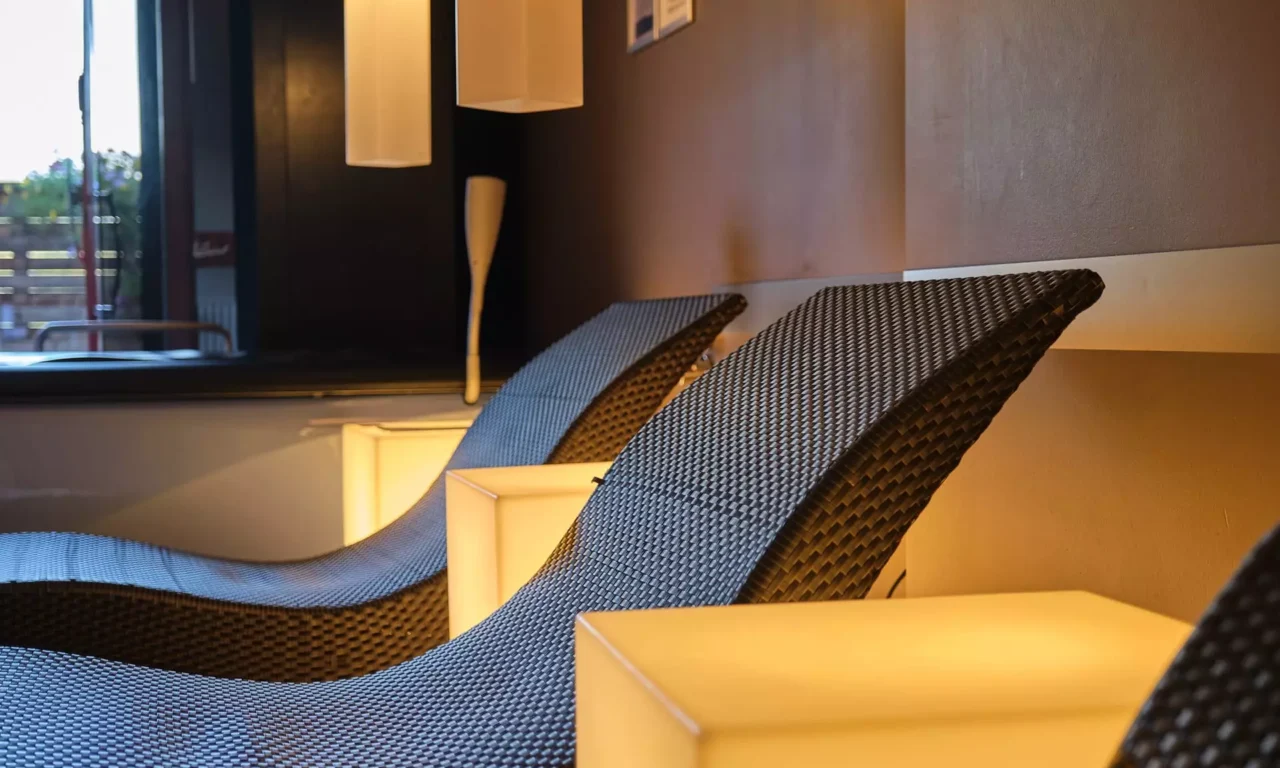 Zwei moderne Relaxliegen aus Rattan mit warmem Licht und gedämpfter Atmosphäre im Gesundheitszentrum Bärenhof Bad Gastein
