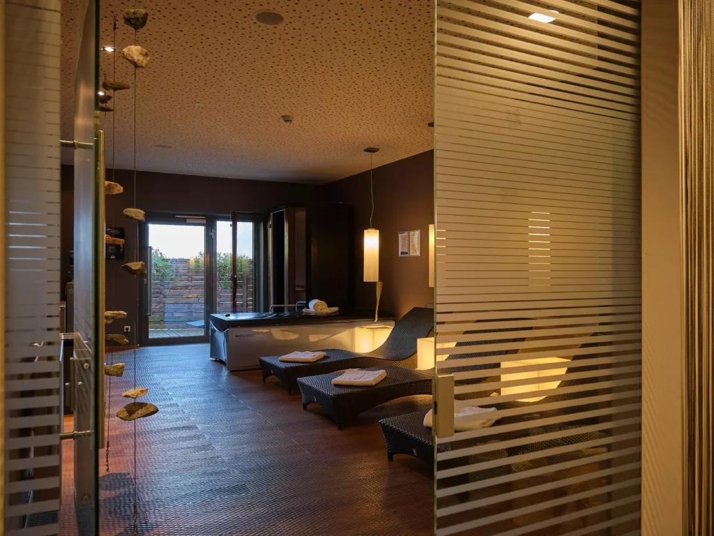 Entspannungsraum im Gesundheitszentrum Bärenhof Bad Gastein mit Liegen, Handtüchern und gedämpfter Beleuchtung für