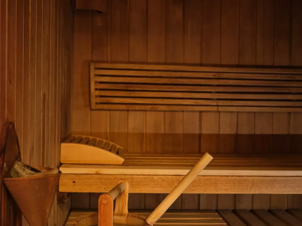 Holzeimer mit Kelle und zusammengerolltes Handtuch in der Sauna im Gesundheitszentrum Bärenhof Bad Gastein