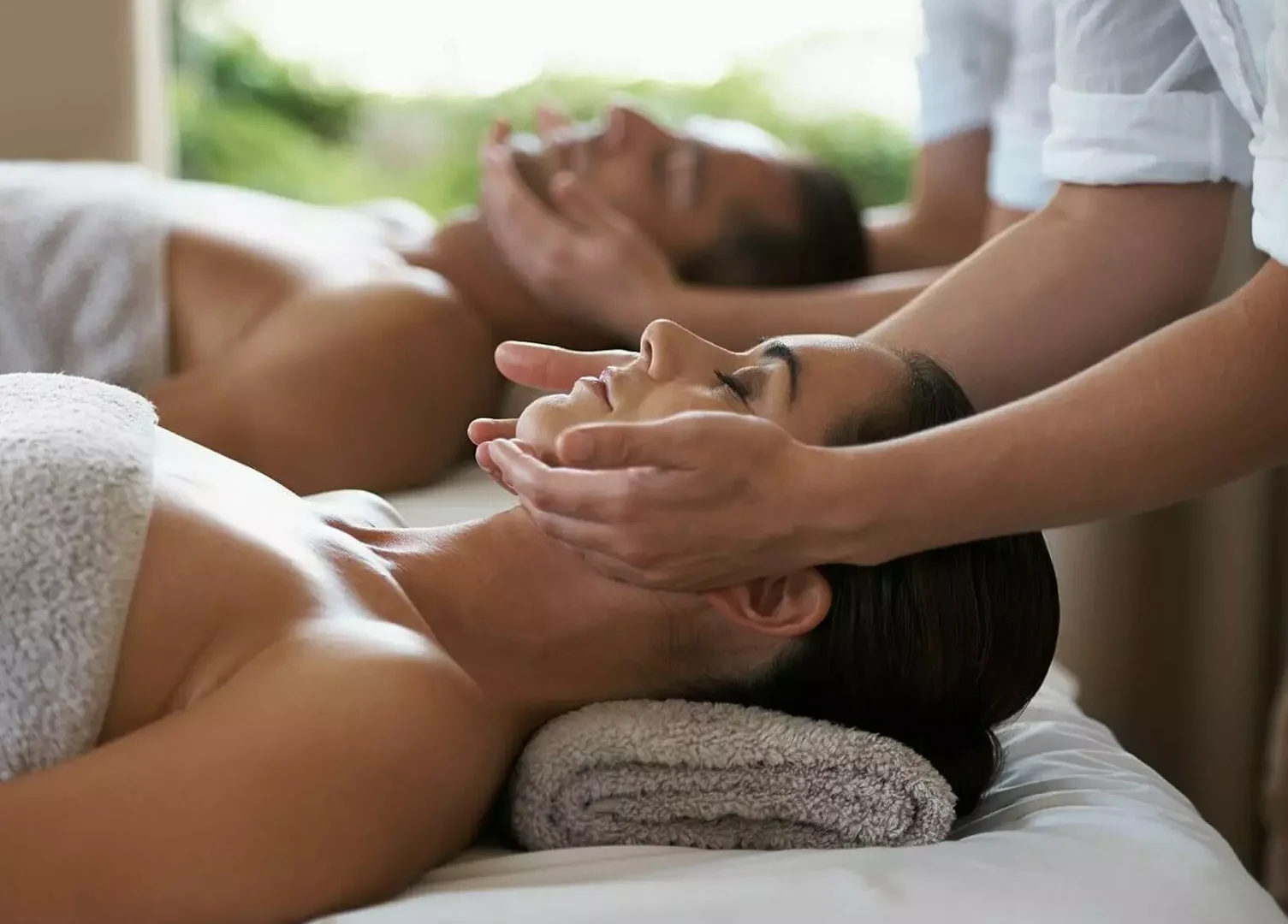 Zwei Personen erhalten im Gesundheitszentrum Bärenhof in Bad Gastein eine entspannende Gesichtsmassage zur Erholung und