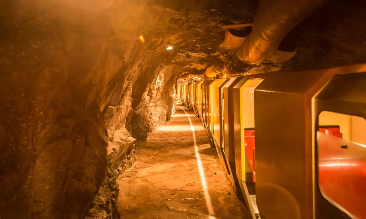 Bergwerksbahn fährt durch beleuchteten Felsstollen im Gesundheitszentrum Bärenhof Bad Gastein zur Therapie und Erholung