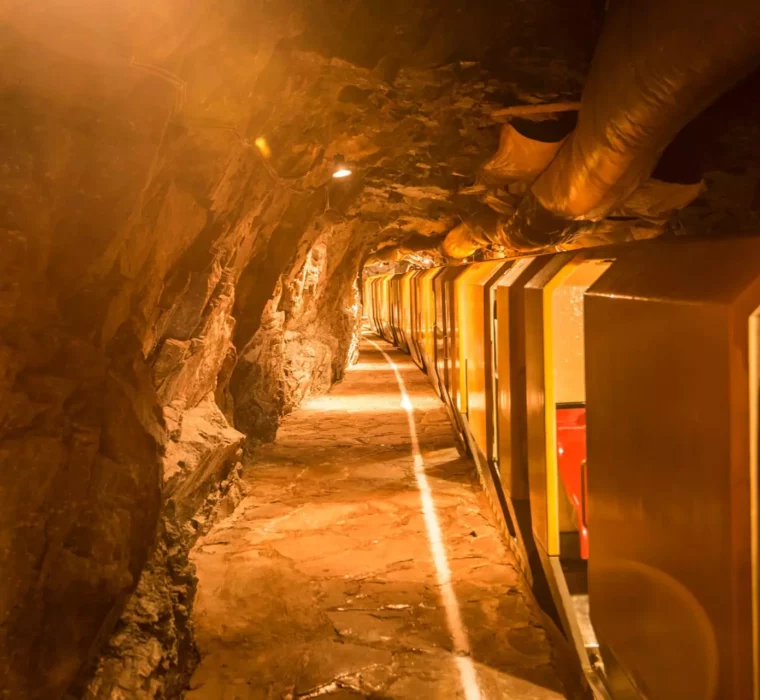 Bergwerksbahn fährt durch beleuchteten Felsstollen im Gesundheitszentrum Bärenhof Bad Gastein zur Therapie und Erholung